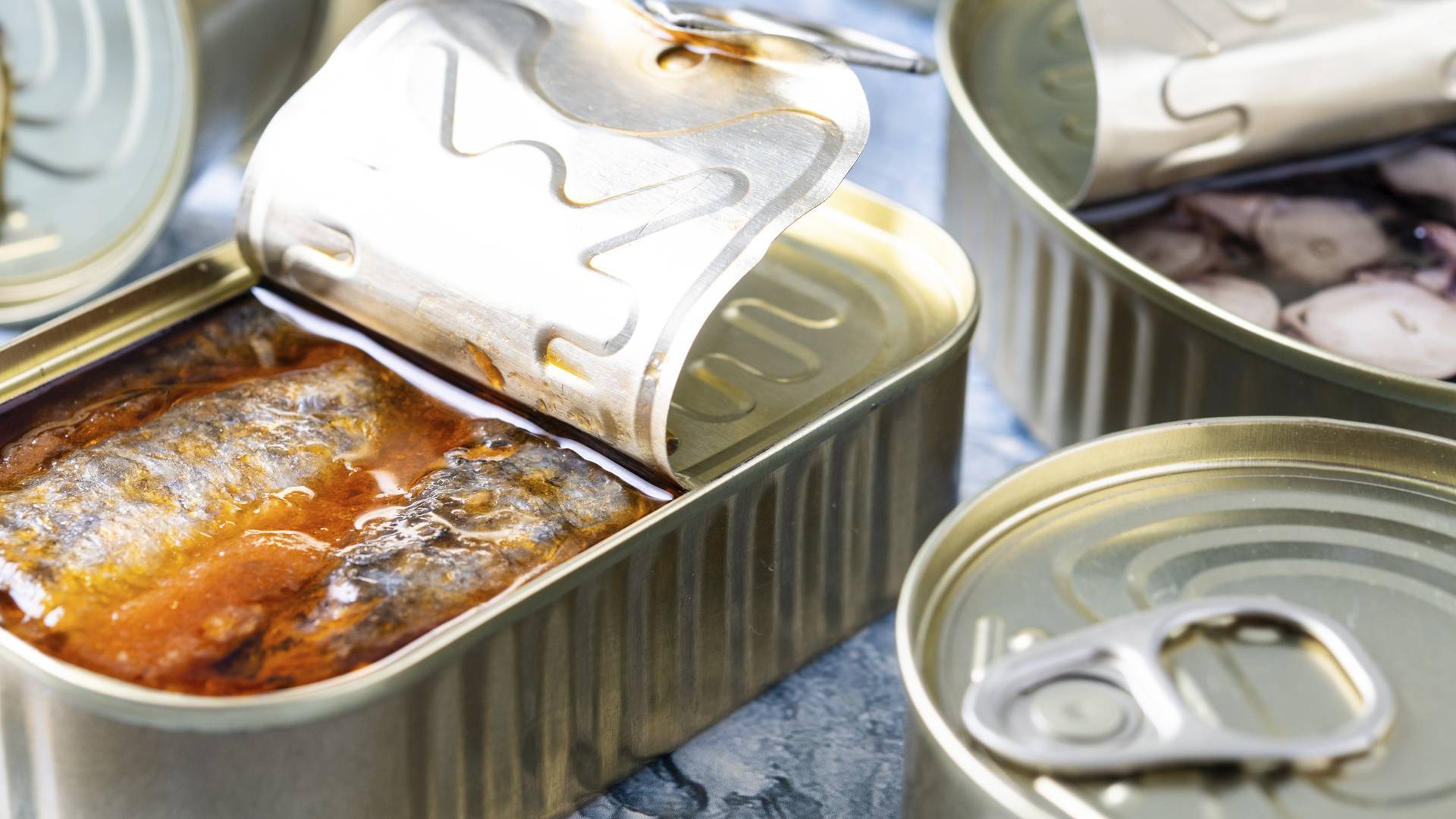 Why should you never keep open cans in the refrigerator?