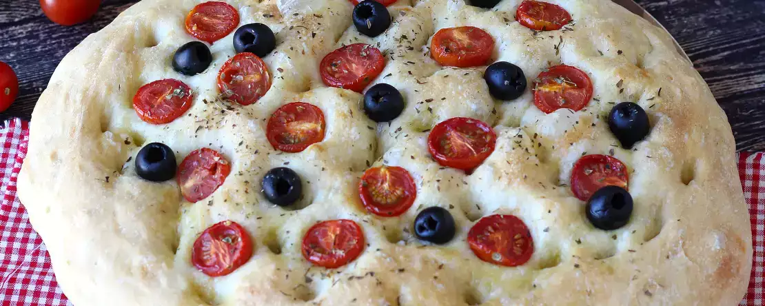 Thick, fluffy focaccia with cherry tomatoes, olives, and oregano