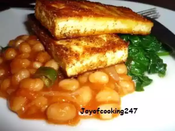 Recipe Marinated tofu-paneer(indian cottage cheese) on a bed of wilted spinach and baked beans