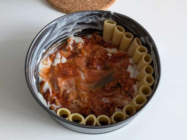 Baked rigatoni cake with sausage, béchamel sauce, and mozzarella - Preparation step 8