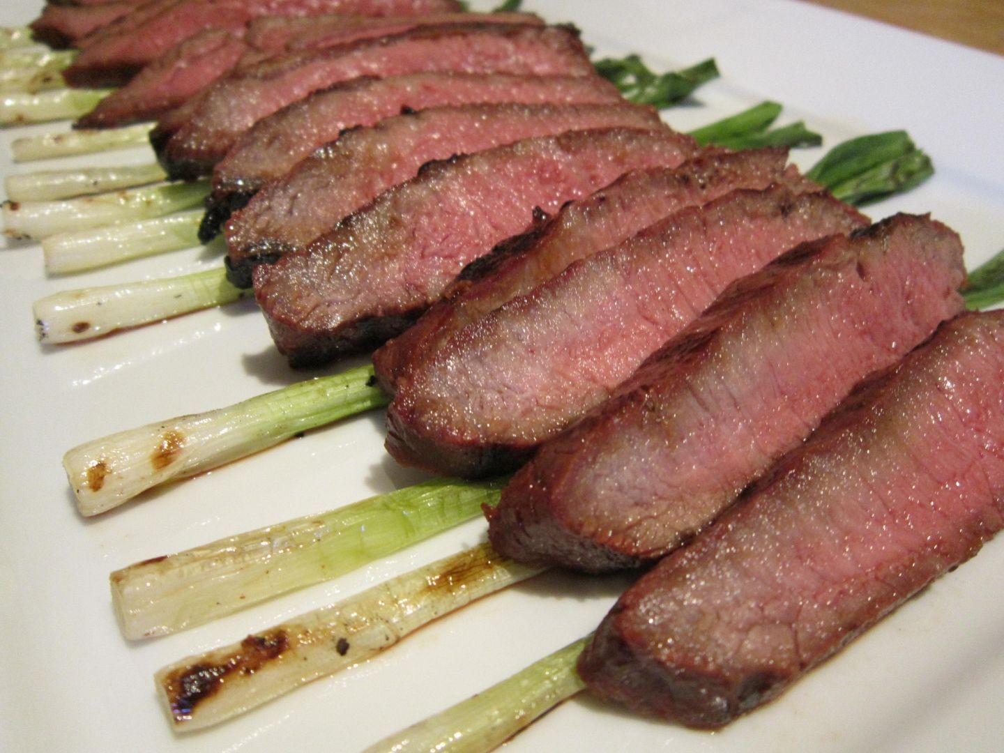 Gingersoy flatiron steak with grilled green onions (visit