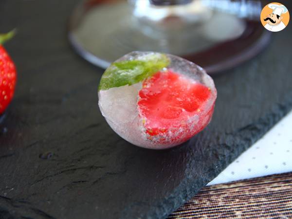 Ice cubes with red berries and mint leaves