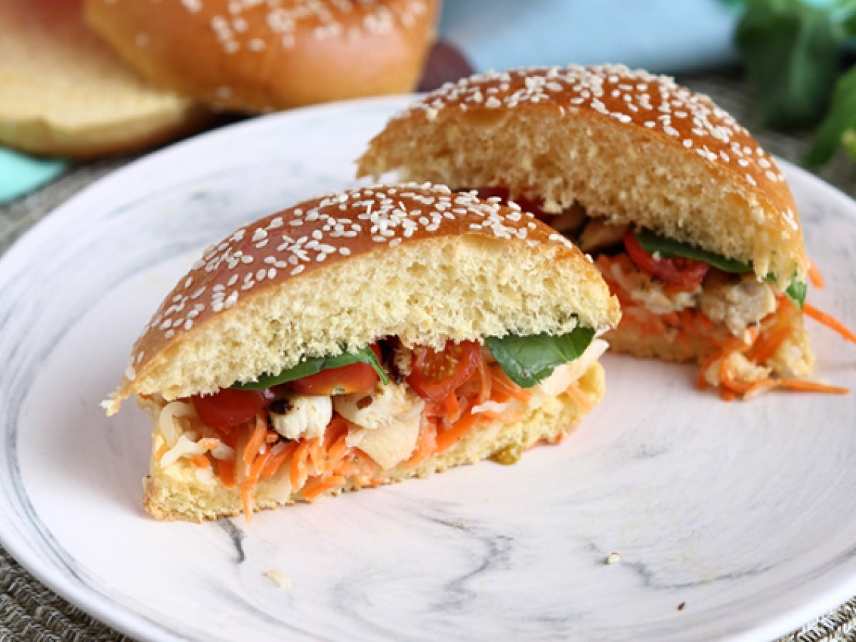 Marinated chicken sandwich with coleslaw, tomatoes, and basil