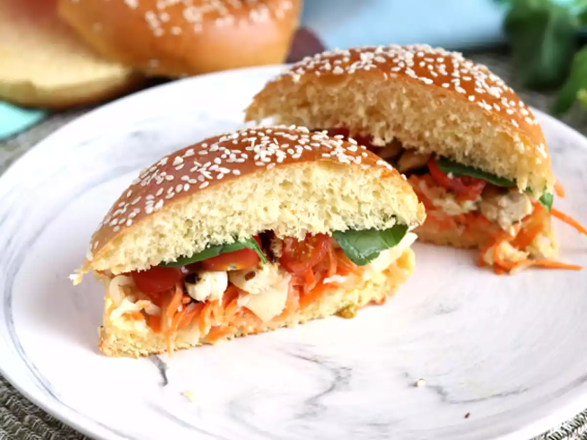 Marinated chicken sandwich with coleslaw, tomatoes, and basil