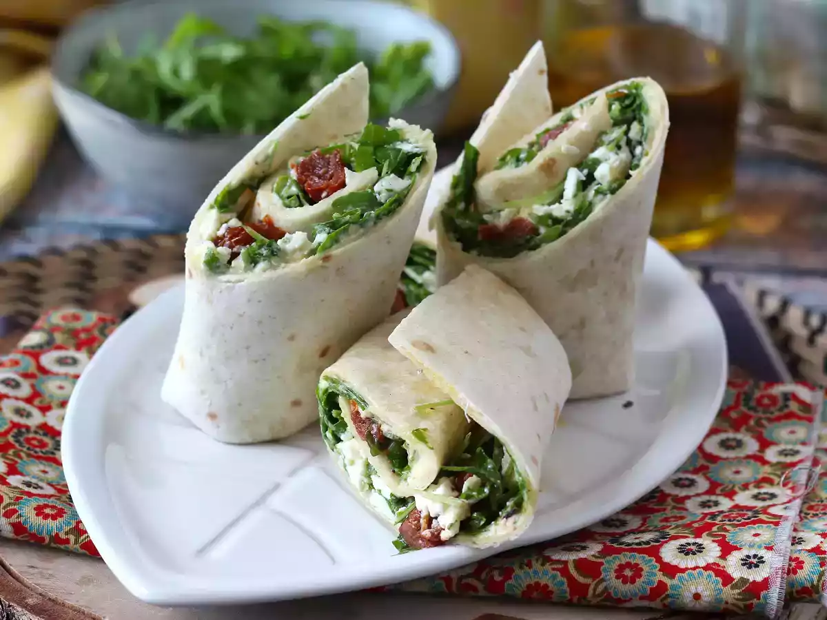 Mediterranean wrap stuffed with hummus, arugula, peppers and feta
