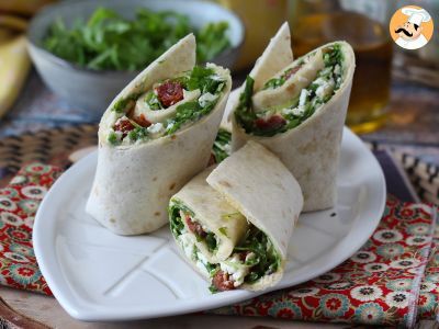 Mediterranean wrap stuffed with hummus, arugula, peppers and feta