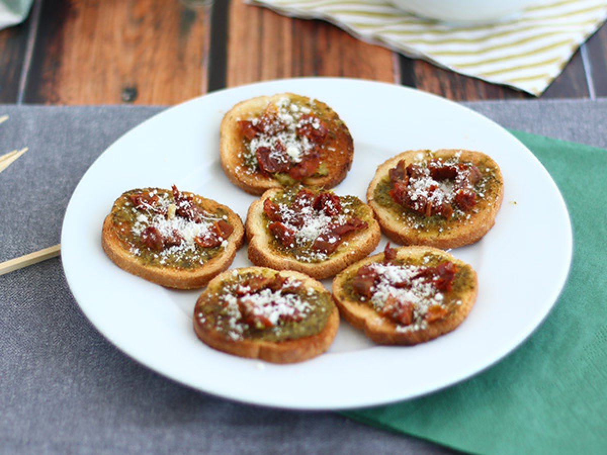 Toasts with pesto, parmesan and sun-dried tomatoes